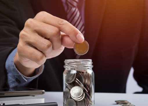 hand-putting-mix-coins-seed-clear-bottle-copyspace-business-investment-growth-concept